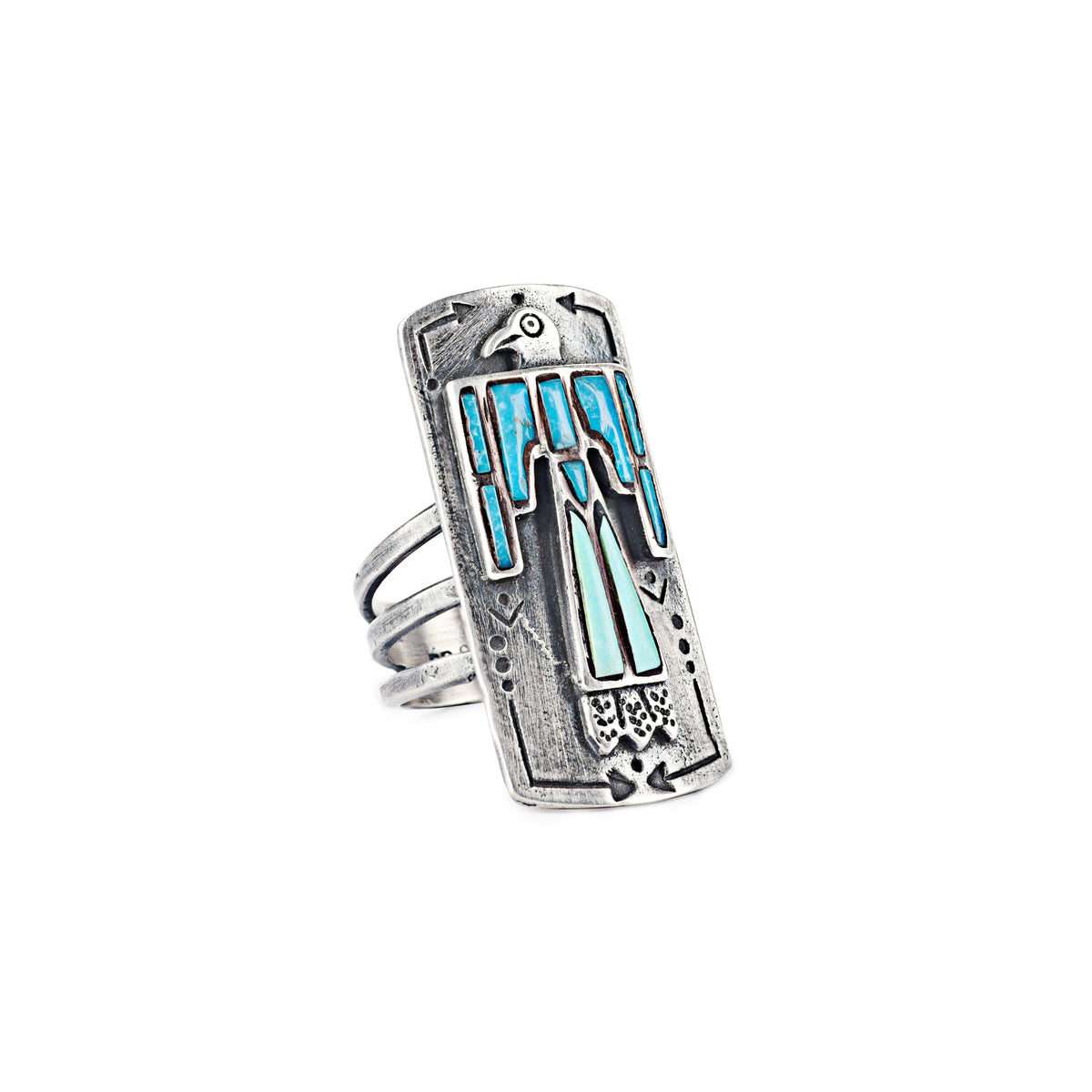 A sterling silver shield ring with blue and light blue turquoise stones inlayed into an intricate thunderbird design. Added stamping and the split shank design of the band make this ring exceptional. 
