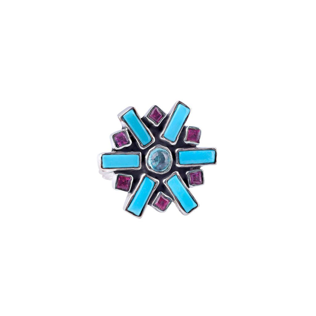 A sterling silver ring with a thin silver band and blue turquoise, aquamarine, and pink tourmaline stones.  