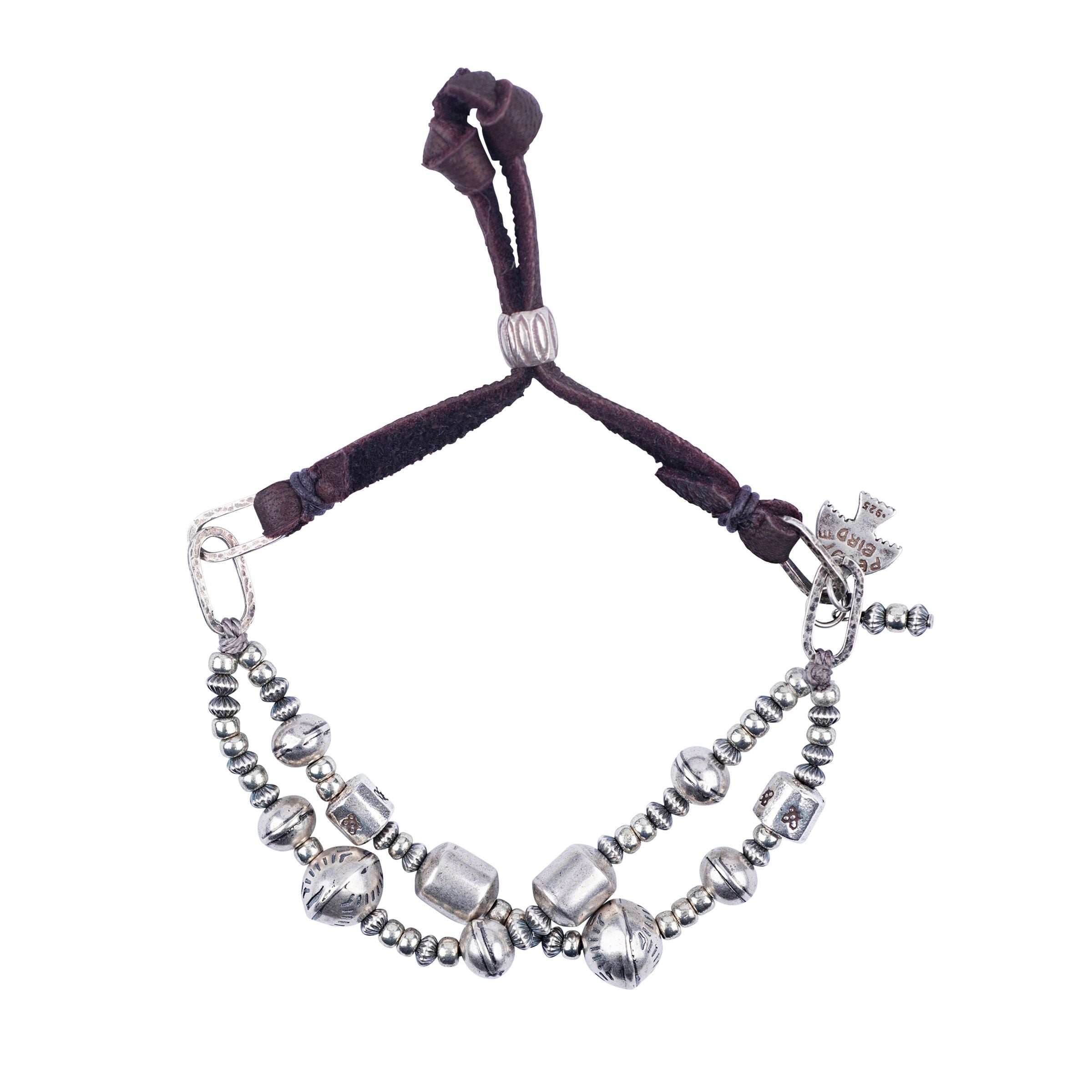 An adjustable bracelet featuring sterling silver beads and soft deerskin leather. 
