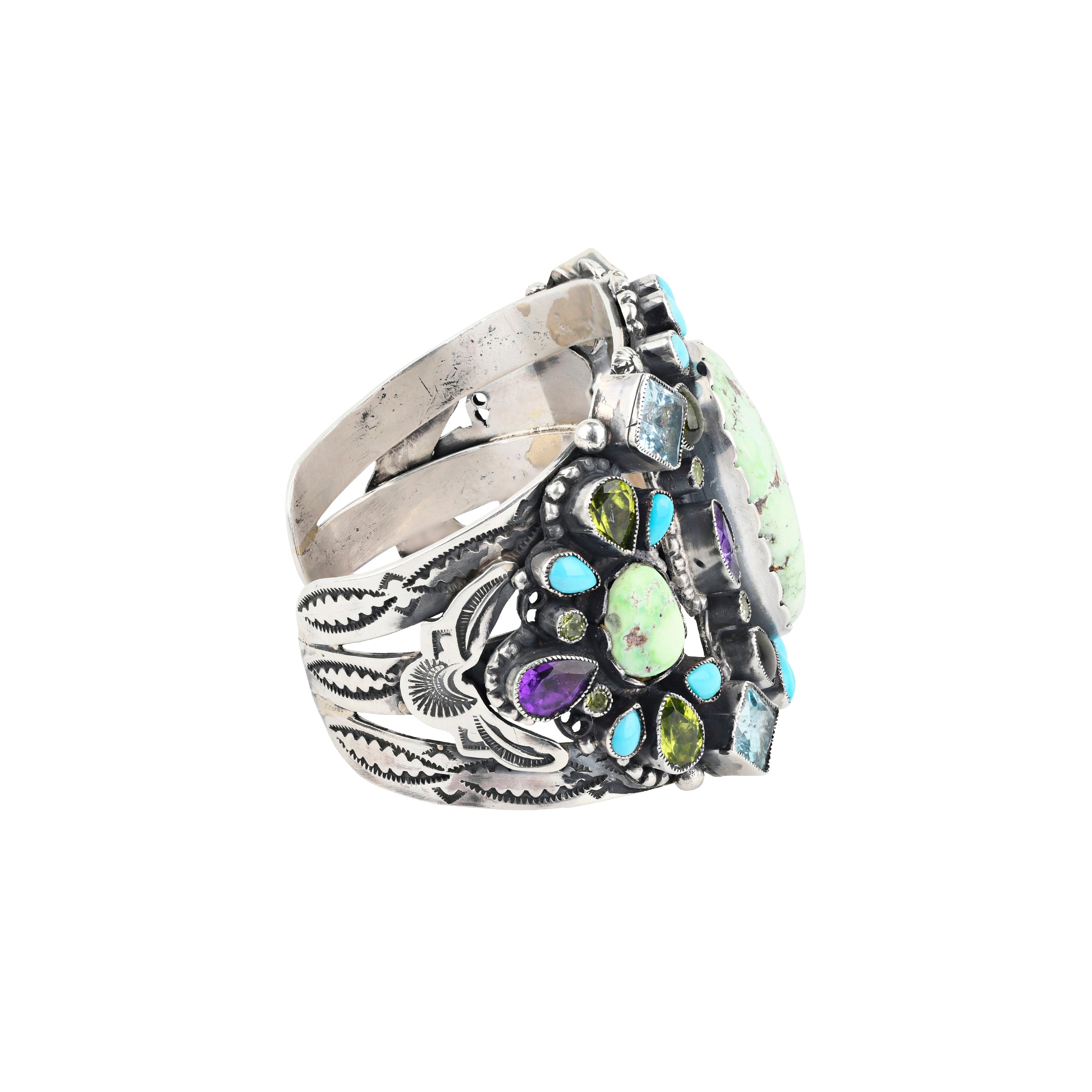 A stunning statement cuff handmade with sterling silver, green turquoise, blue turquoise, amethyst, aquamarine, and peridot finished with western style stamping and detailing