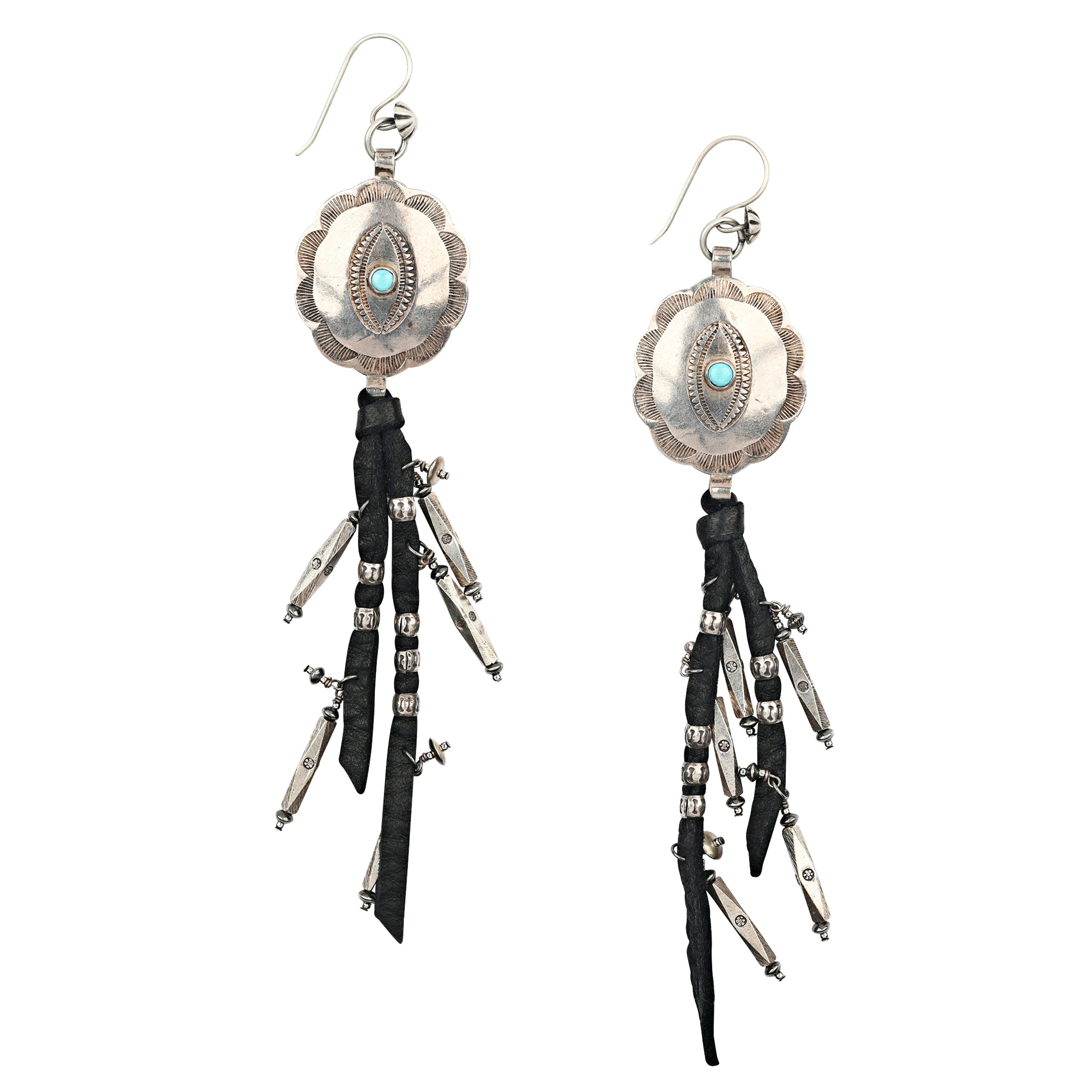 A pair of Sterling Silver Earrings featuring large Southwestern conchos with stamped detailing finished with leather fringe and charms of Sterling Silver beading.