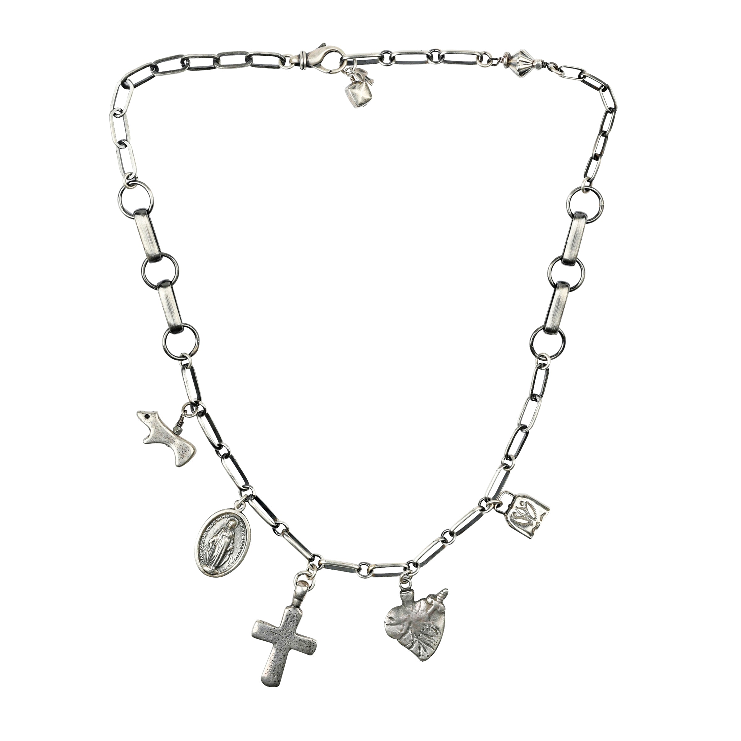 A silver chain necklace featuring the Mountain Spirit Cross Pendant with faith based charms including a Sacred Heart, Mother Mary, a bell, and a Bear totem