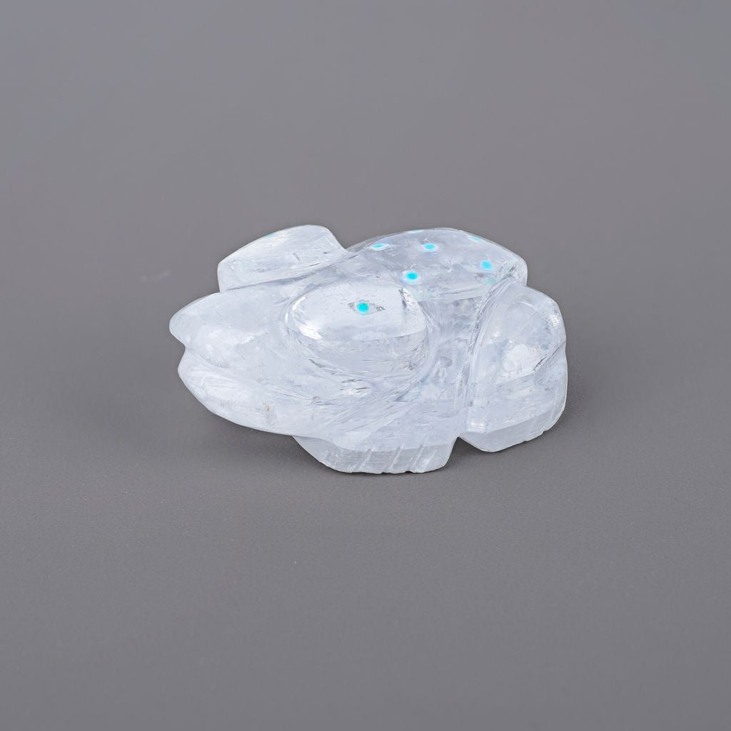 A clear quartz frog fetish with turquoise accents, hand carved in the USA.