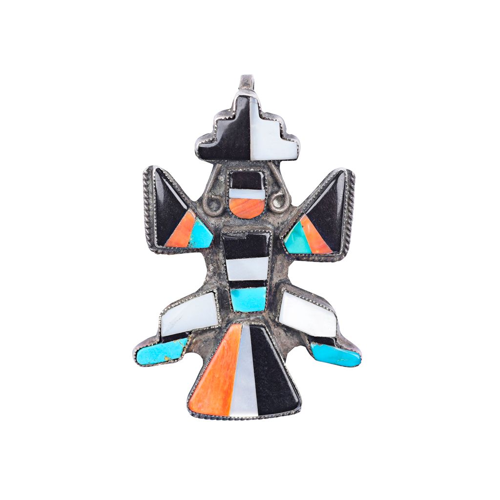 A vintage Zuni mini knifewing pin with geometric patterns and multicolored stones attached to a metal clip.