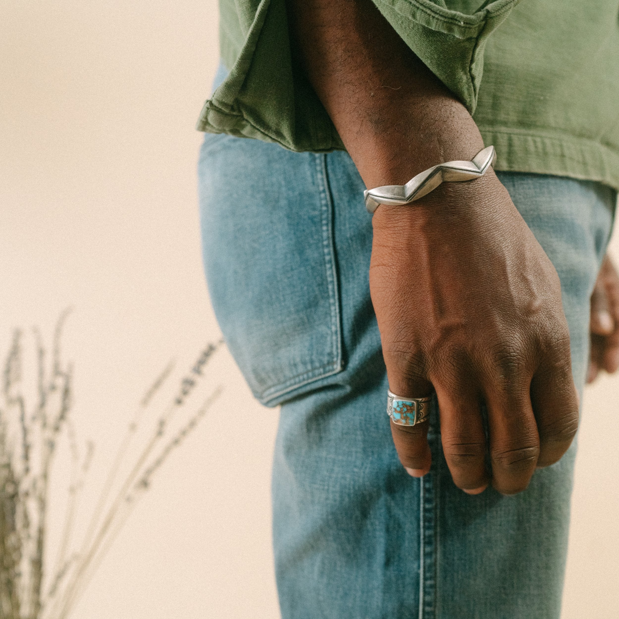 A sterling silver cuff bracelet from artisan Jock Favour with a zigzag pattern, featuring a textured surface and a snake motif. Made in USA.