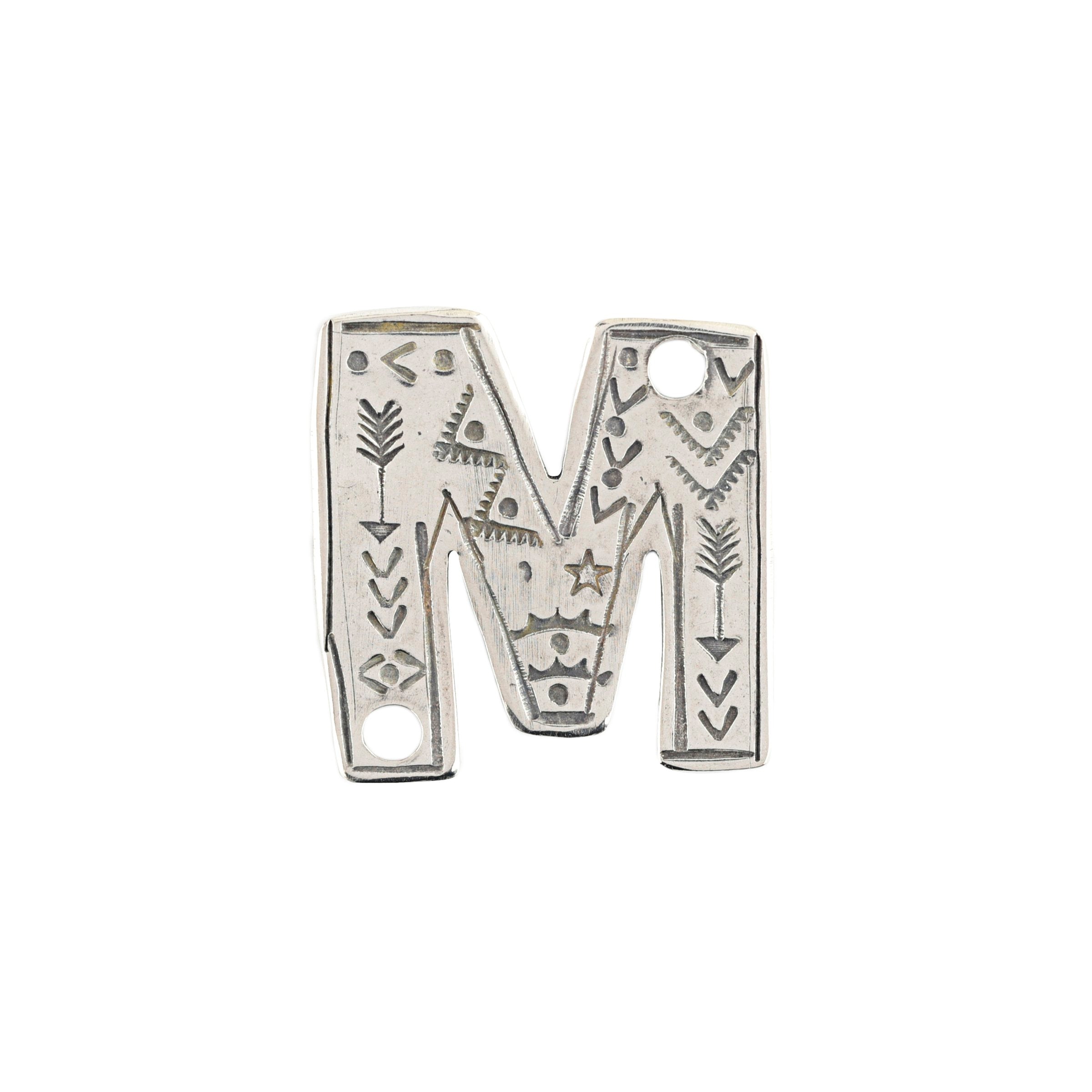 A sterling silver M Charm from artist Joe Eby that is a perfect addition to any hat or jacket.