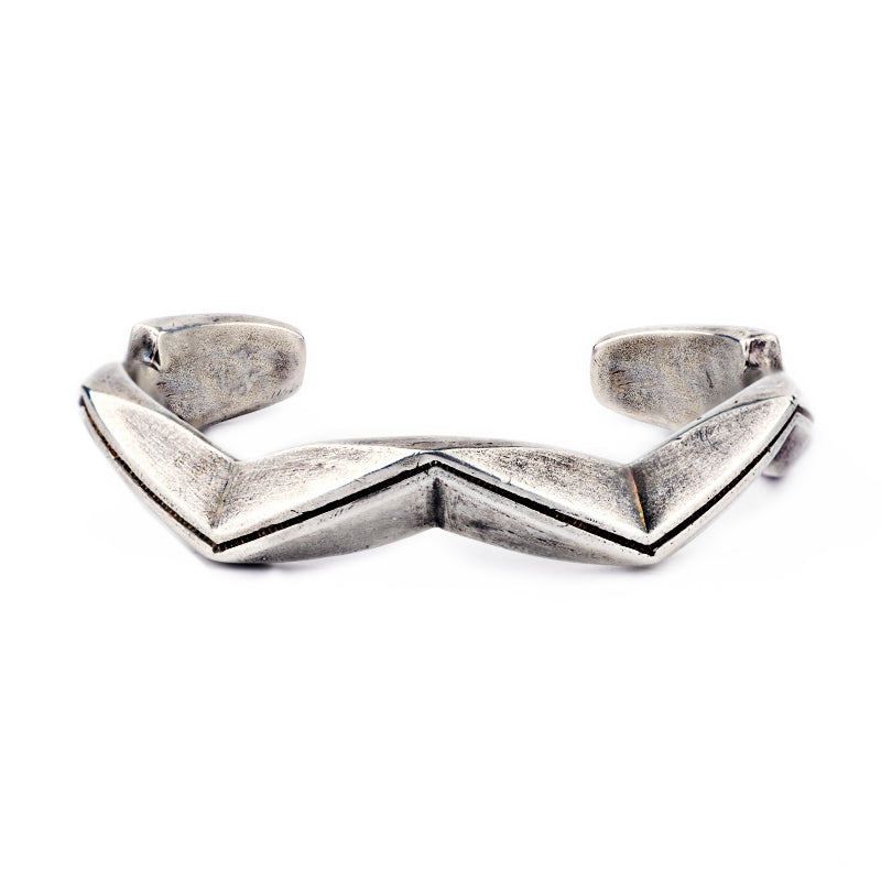 A sterling silver cuff bracelet from artisan Jock Favour with a zigzag pattern, featuring a textured surface and a snake motif. Made in USA.