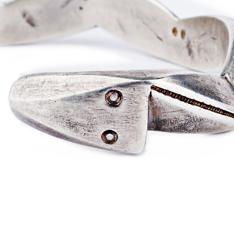 A sterling silver cuff bracelet from artisan Jock Favour with a zigzag pattern, featuring a textured surface and a snake motif. Made in USA.