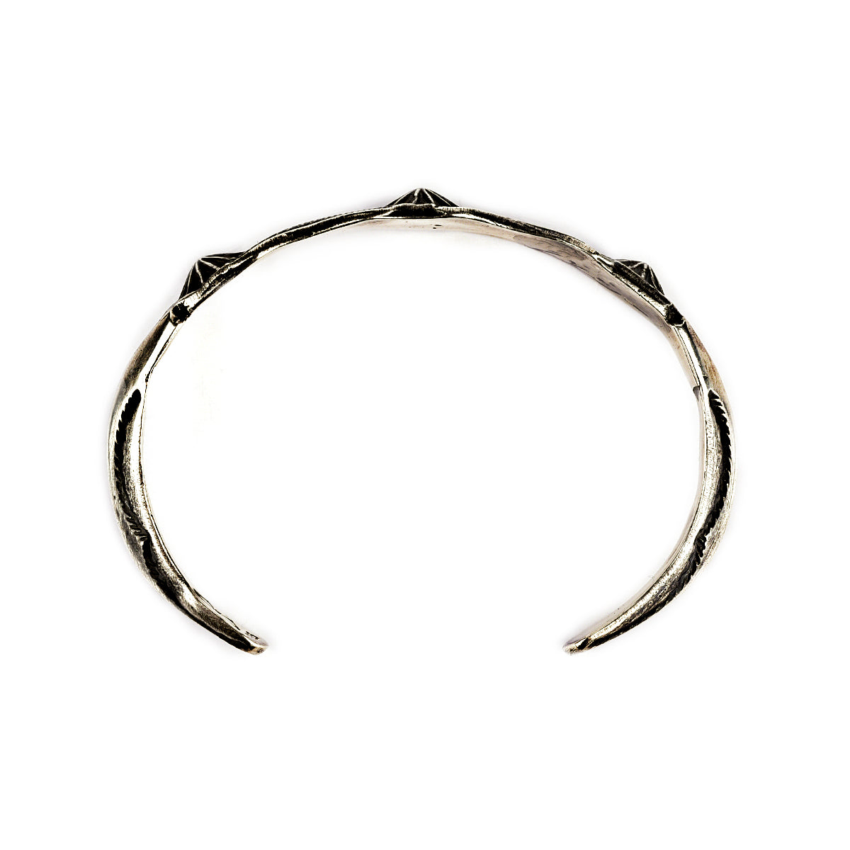 A sterling silver cuff bracelet from artisan Buffalo with intricate stamped geometric patterns and a branded clasp. Made in USA.