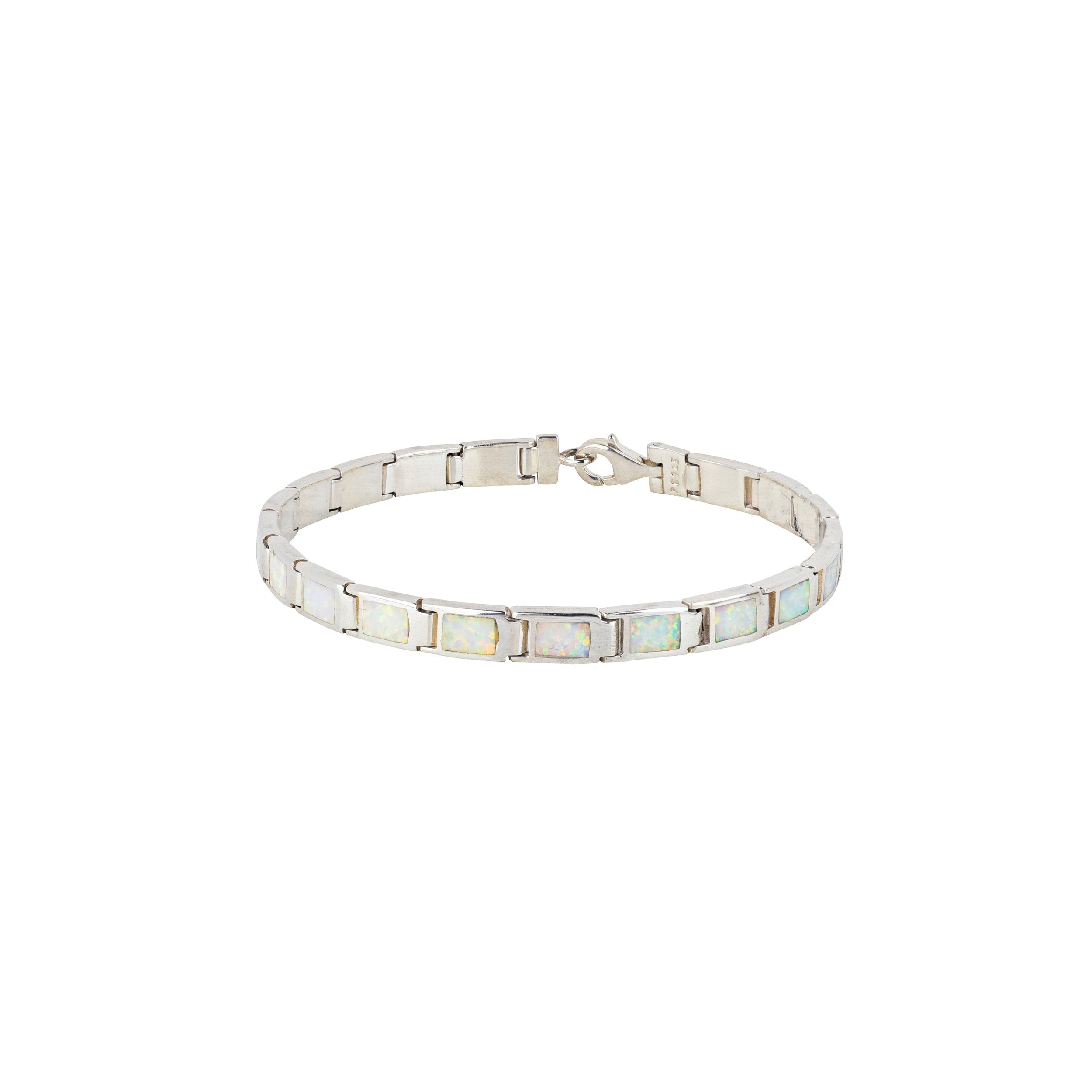 A silver bracelet with white opal stones, featuring a clasp.