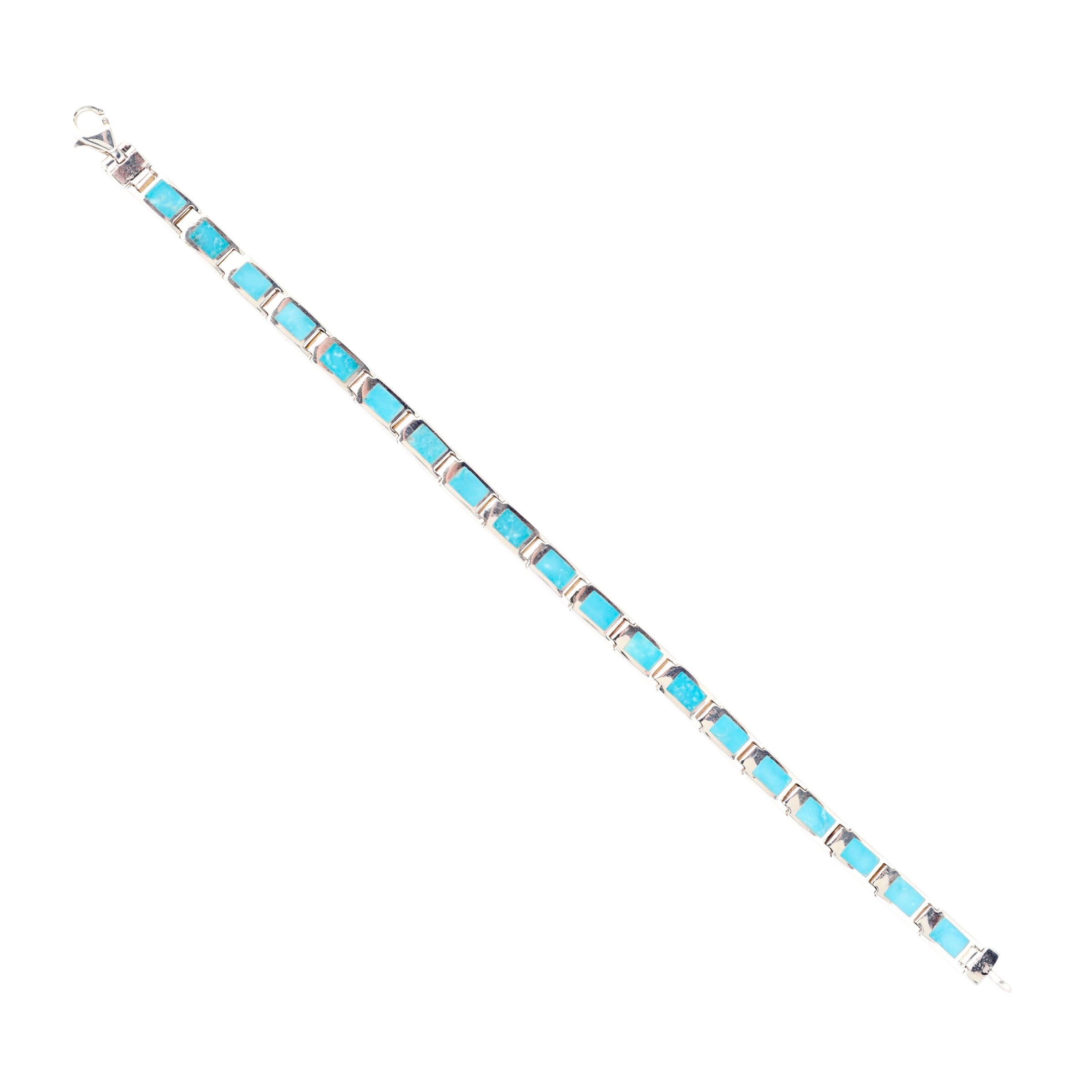 A silver bracelet with green and blue turquoise stones, featuring a clasp.